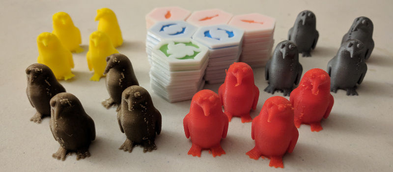 All of the printed tiles in stacks, with penguins of different colours standing around them