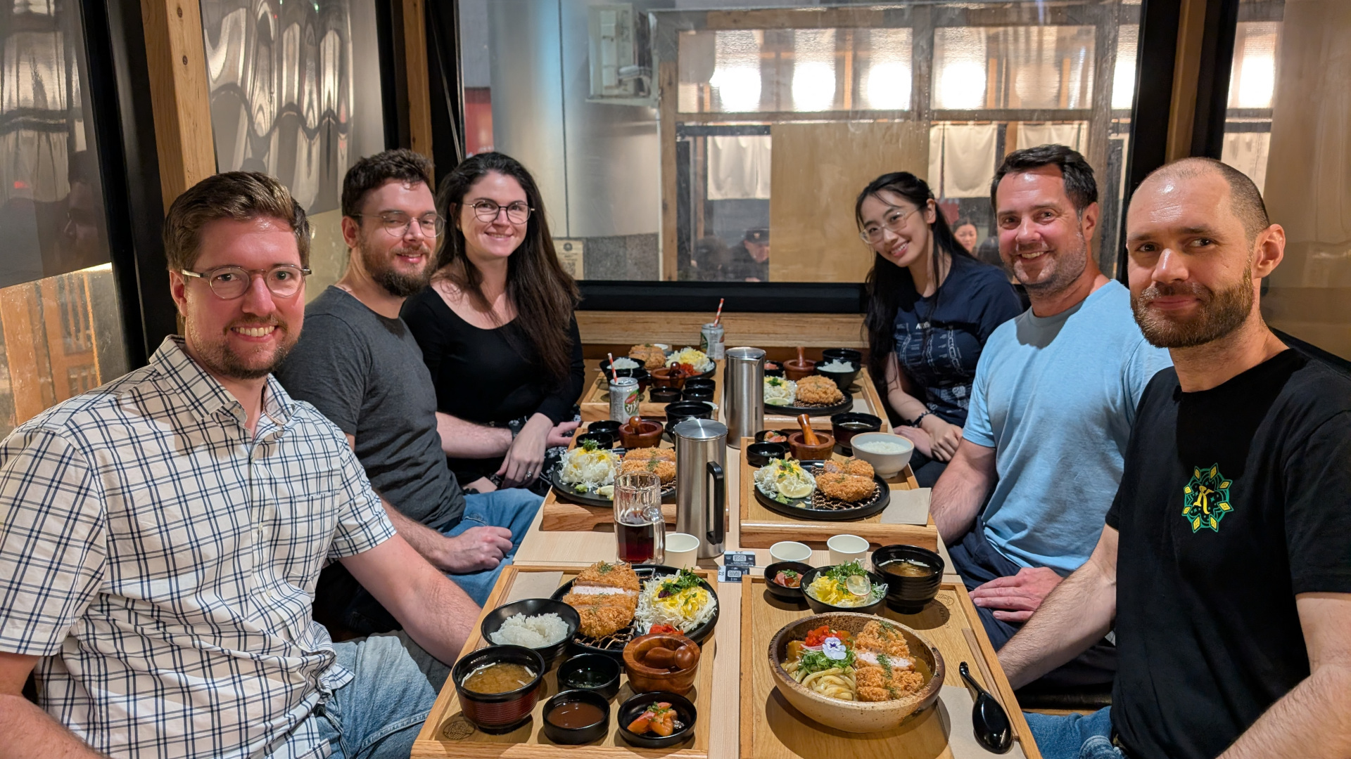 A selfie of two hikers standing in front of bush land and a mountain