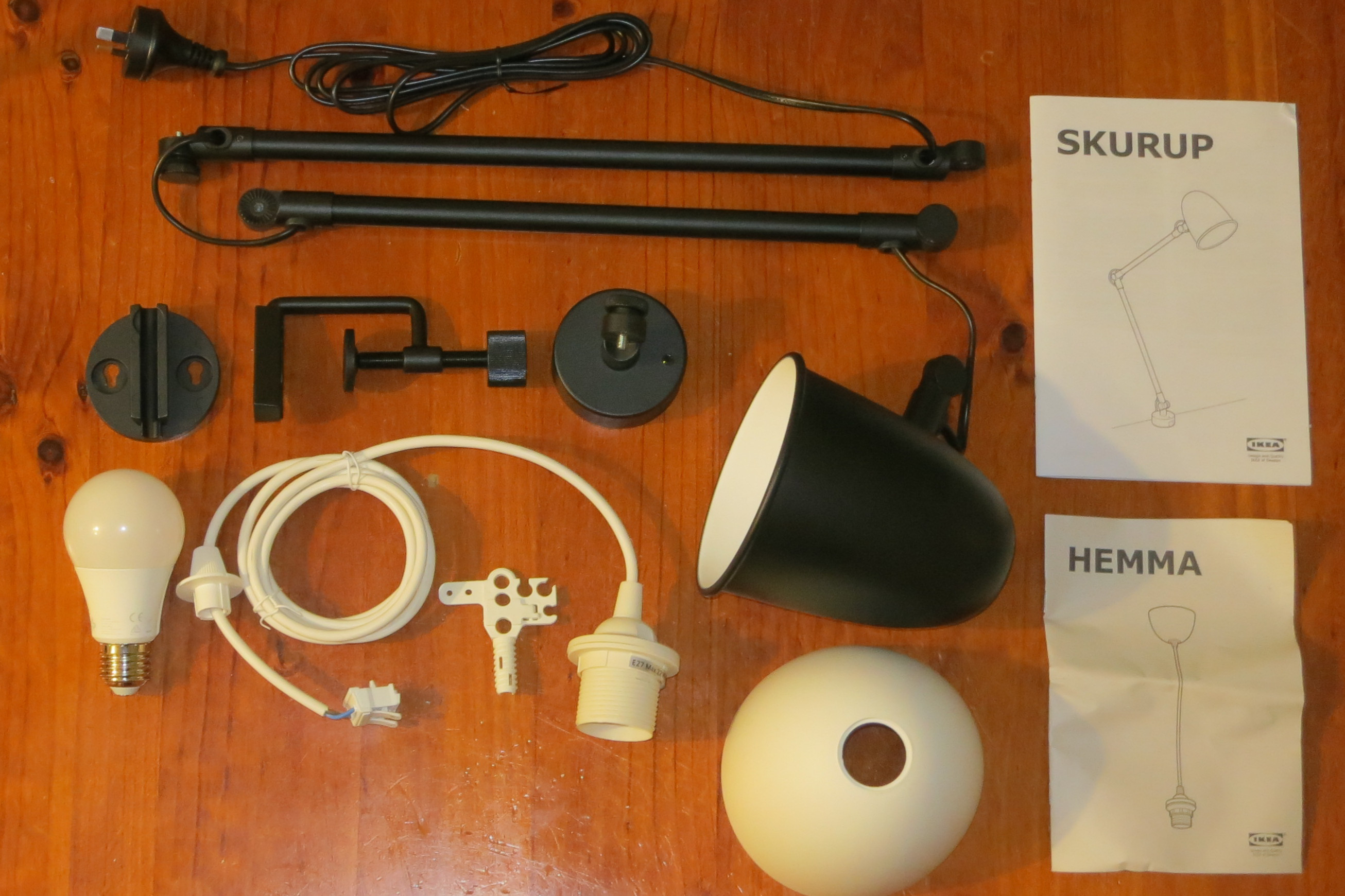 A SKURUP lamp, donor HEMMA cord set, and Sengled LED bulb laid out on a table